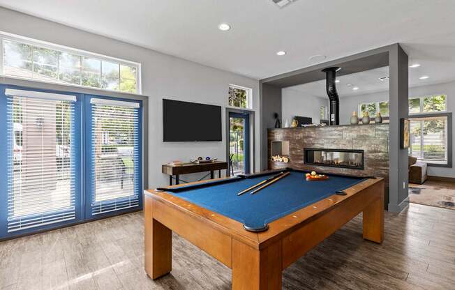 a pool table in a living room with a fireplace and a television