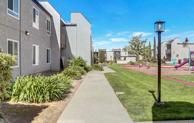 A residential area with a sidewalk and a playground.
