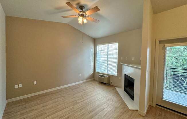 A room with a ceiling fan and a fireplace at Wilsonville Summit Apartments, Wilsonville , OR