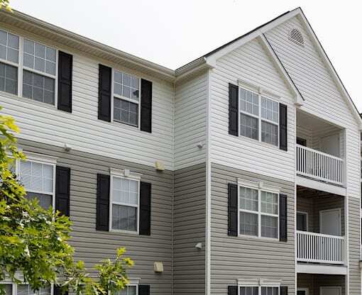 A two-story apartment building with a balcony on the second floor.