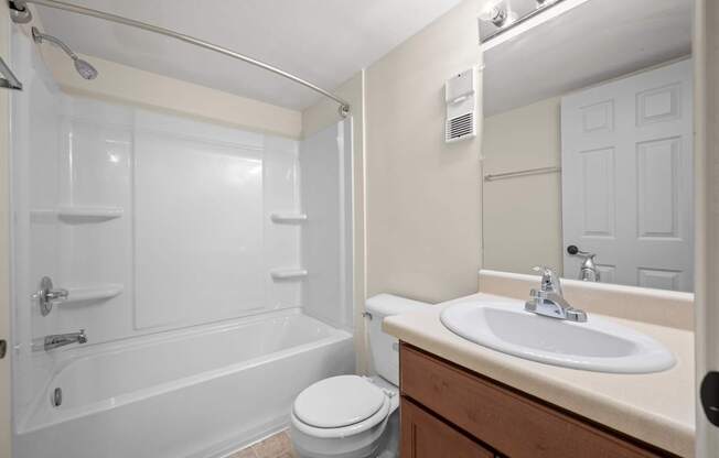 A white bathroom with a toilet, sink, and bathtub.