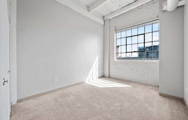 A room with a large window and a white door.