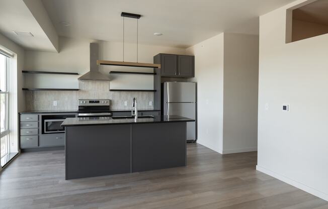 a kitchen with a black island and stainless steel appliances at Riverhouse Apartments, Fargo