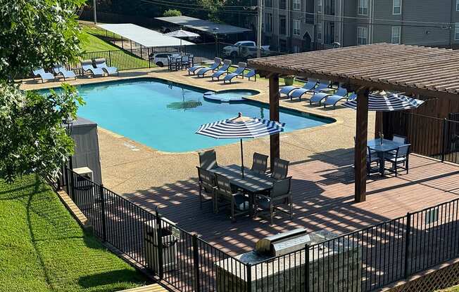 a large swimming pool with tables and umbrellas