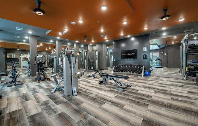 a gym with weights and cardio equipment in a building