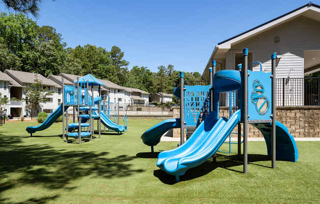A playground with a blue slide and a climbing frame.