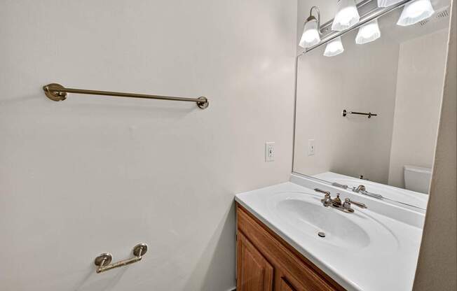 A bathroom with a white sink and a white towel rack.