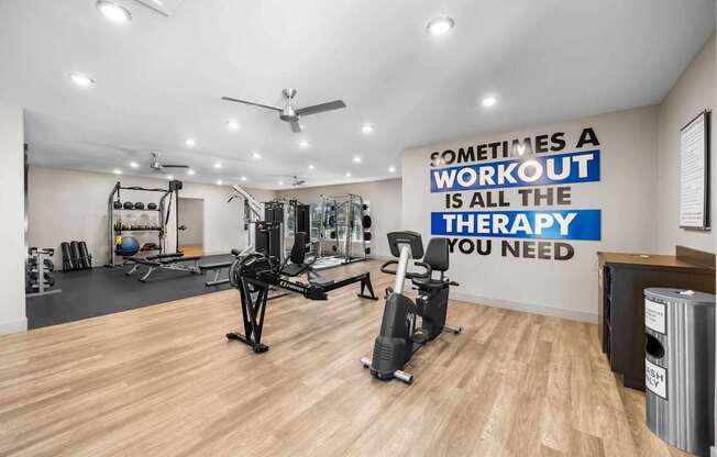 A gym with a quote on the wall that says "Sometimes a workout is all the therapy you need".