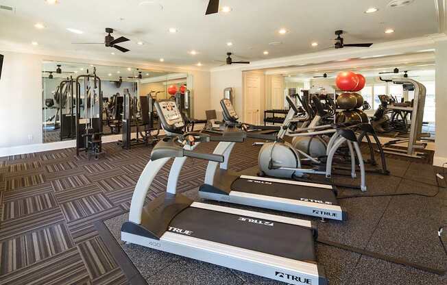 A gym with treadmills, elliptical machines, and other exercise equipment.