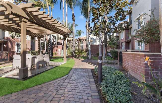 A walkway with a pergola and a wall with a flower on it.