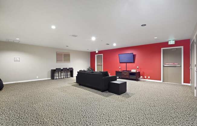 a large living room with a red wall and black furniture