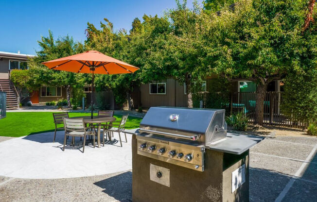 a gas grill on a patio with a table and umbrella at Element LLC, Sunnyvale, 94086