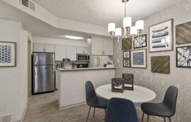 A kitchen with a table and chairs.