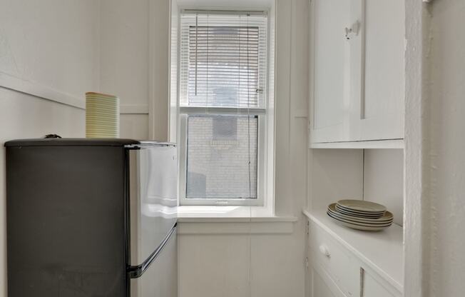 a small kitchen with a refrigerator and a window