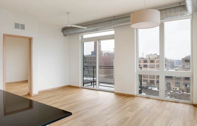 A room with a black table and a view of the city through the windows.