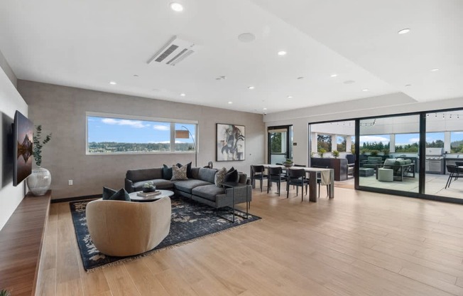 A modern living room with a large window and a view of the sky.