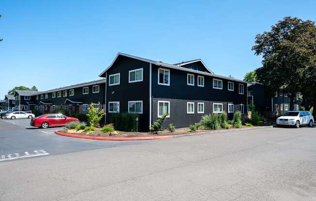 A black building with a parking lot in front of it.