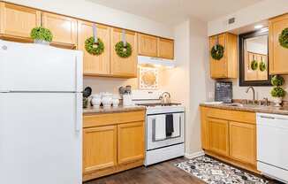 a kitchen with white appliances and wooden cabinets