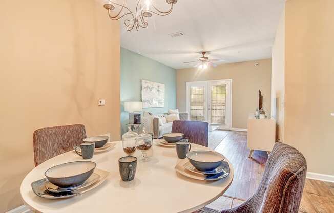 a dining room with a table and chairs and a ceiling fan