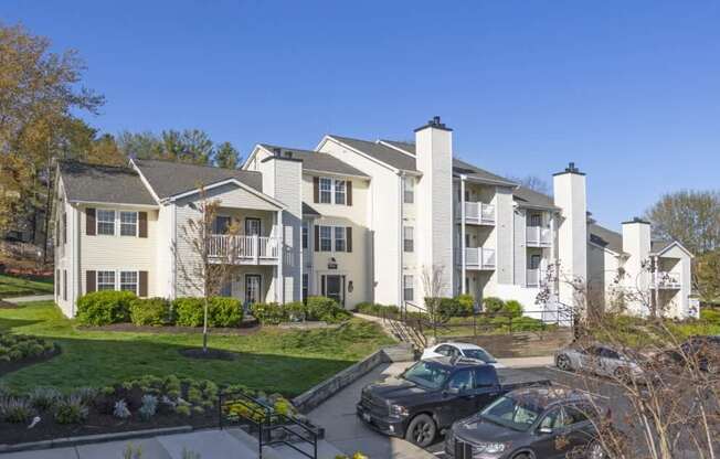 A row of townhouses with cars parked in front.