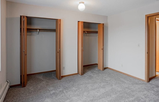 a bedroom with three closets and a carpeted floor