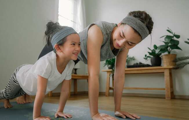 mother and daughter doing yoga at home