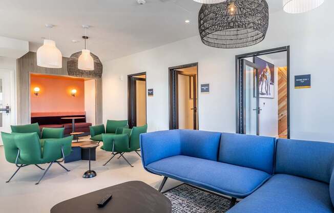 A blue couch is in the middle of a room with a black table in front of it.