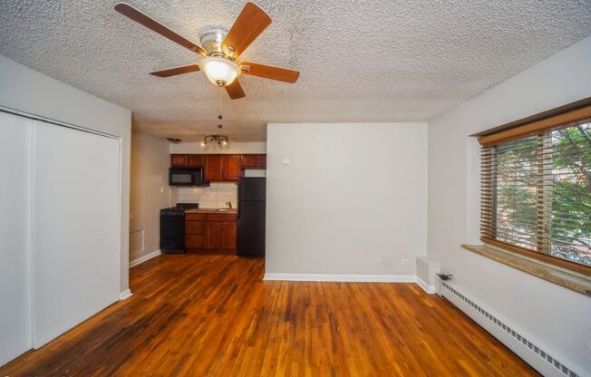 Living room with hardwood flooring and a ceiling fan