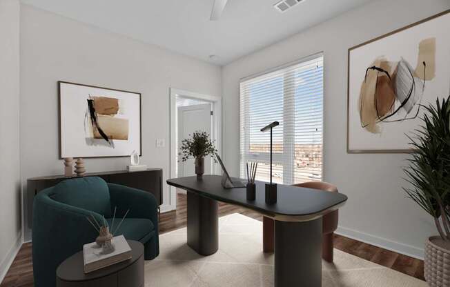 A living room with a blue armchair, a black table, and a painting on the wall.