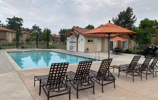 our apartments have a swimming pool with chairs and an umbrella