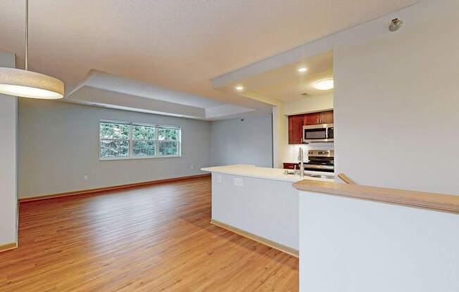 A kitchen with a white counter and wooden floors.