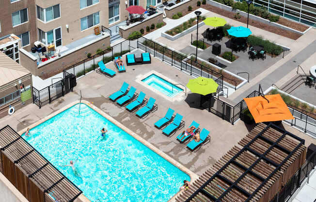 an overhead view of a swimming pool with chairs and umbrellas