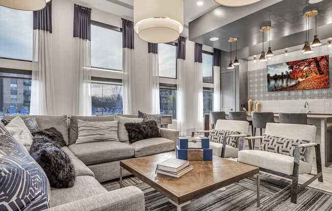 A modern living room with a grey sofa, a wooden coffee table, and a large painting on the wall.