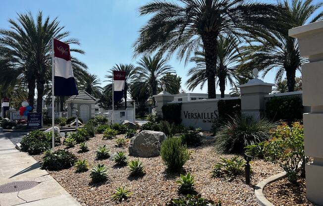 A garden with a Versailles sign in the background.