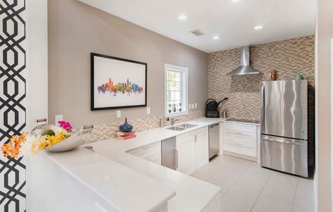 A modern kitchen with a white countertop and a fridge on the right.