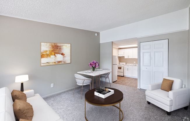 A living room with a white couch, a coffee table, and a painting on the wall.