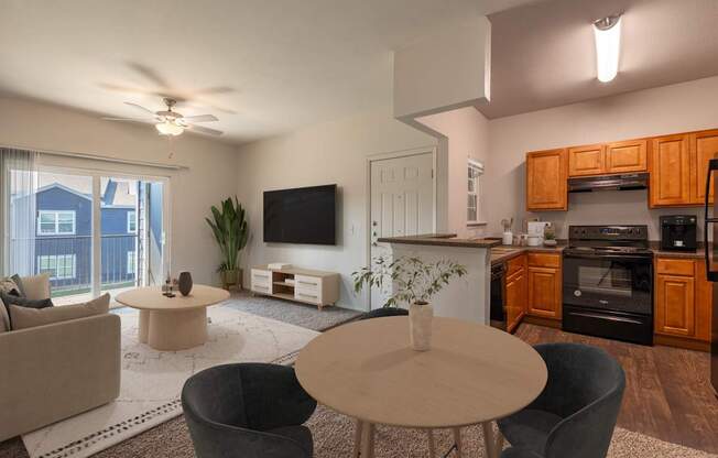 A modern living room with a flat screen TV, a kitchen area, and a dining table.