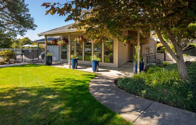 a sidewalk in front of a house with a tree
