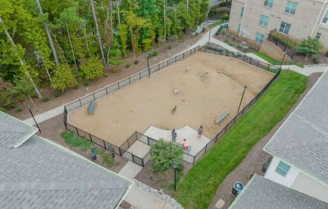 an aerial view of a fenced in dog park in a residential neighborhood