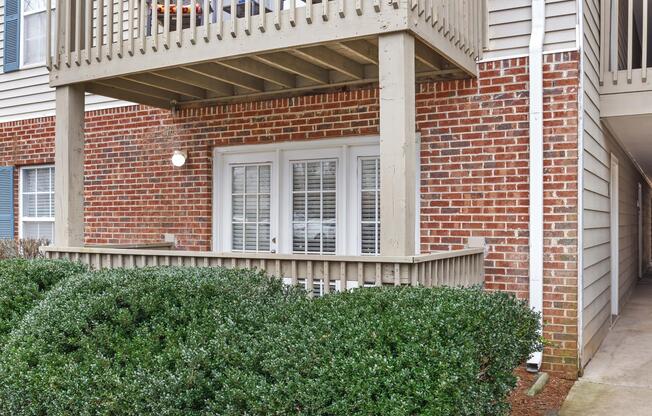 A fenced patio attached to a brick building at Ashley Oaks Apartments in Greensboro, North Carolina