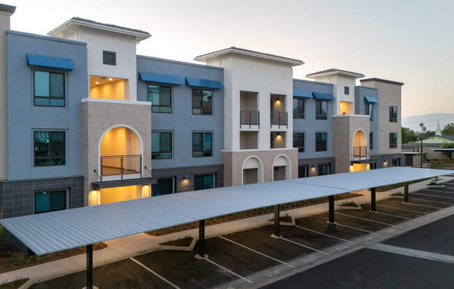 A modern building with a parking lot in front.