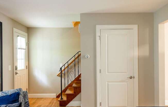 A living room with a couch, chair, and stairs.