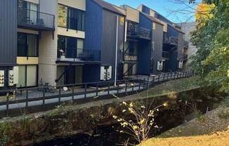 A row of modern buildings with balconies overlook a canal.
