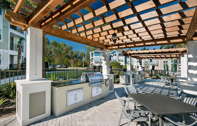 A wooden pergola over a table with chairs.