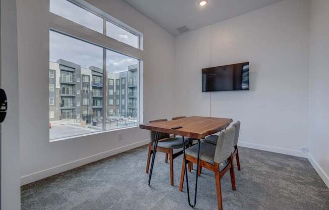 a dining room with a large window and a table with chairs