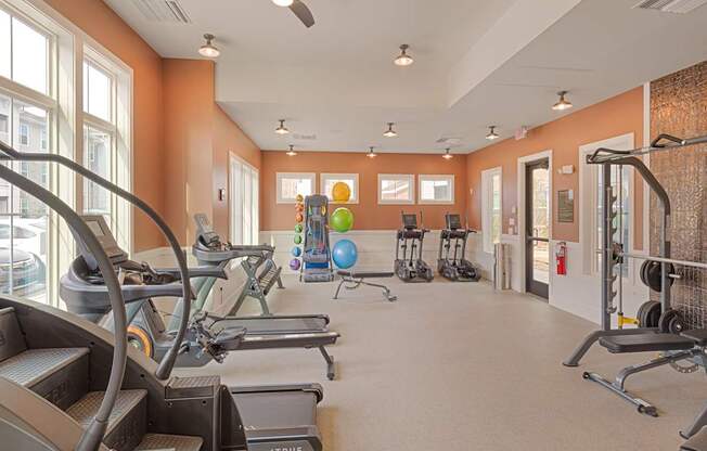 A gym with treadmills, elliptical machines, and other exercise equipment.