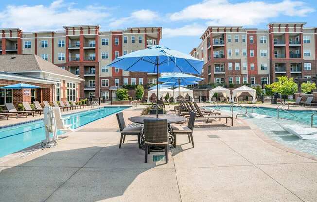 A Pool Area With Table and Chairs at The Aster Apartments, Cary, North Carolina