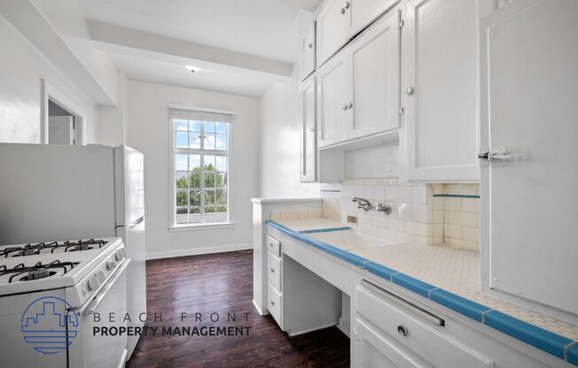 a white kitchen with white cabinets and a blue counter top