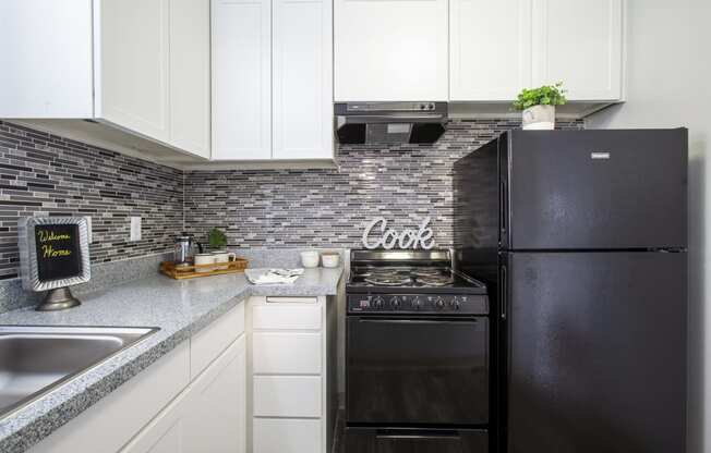 a small kitchen with black appliances and white cabinets