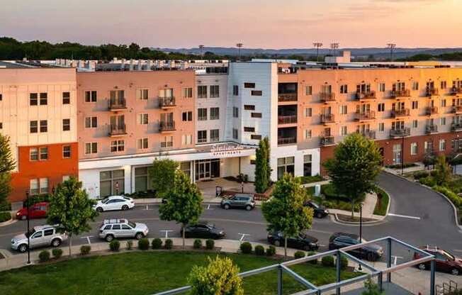 A parking lot is in front of a white and orange building.